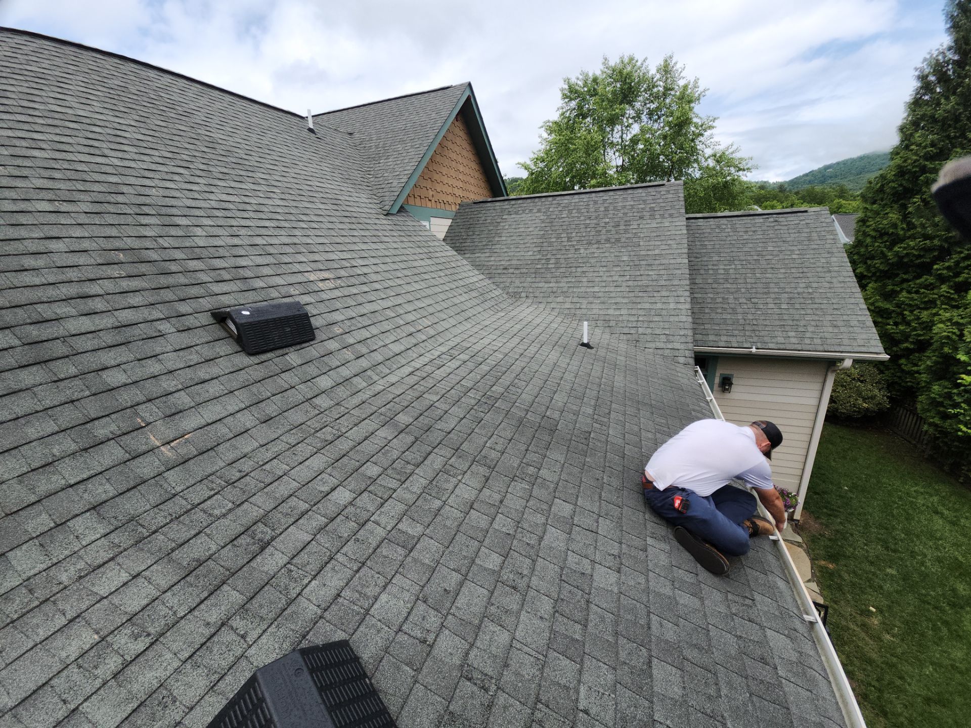 A man is working on the roof of a house.