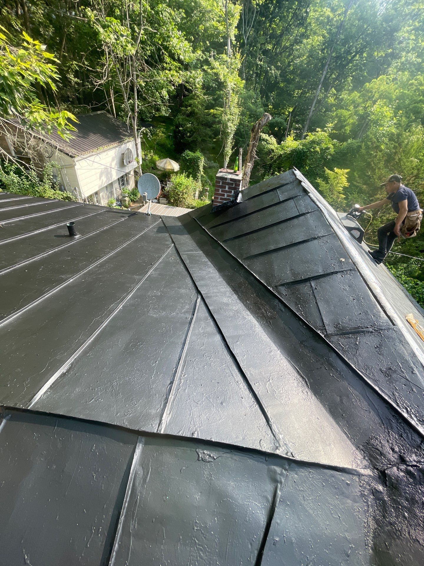 A man is sitting on the roof of a house.
