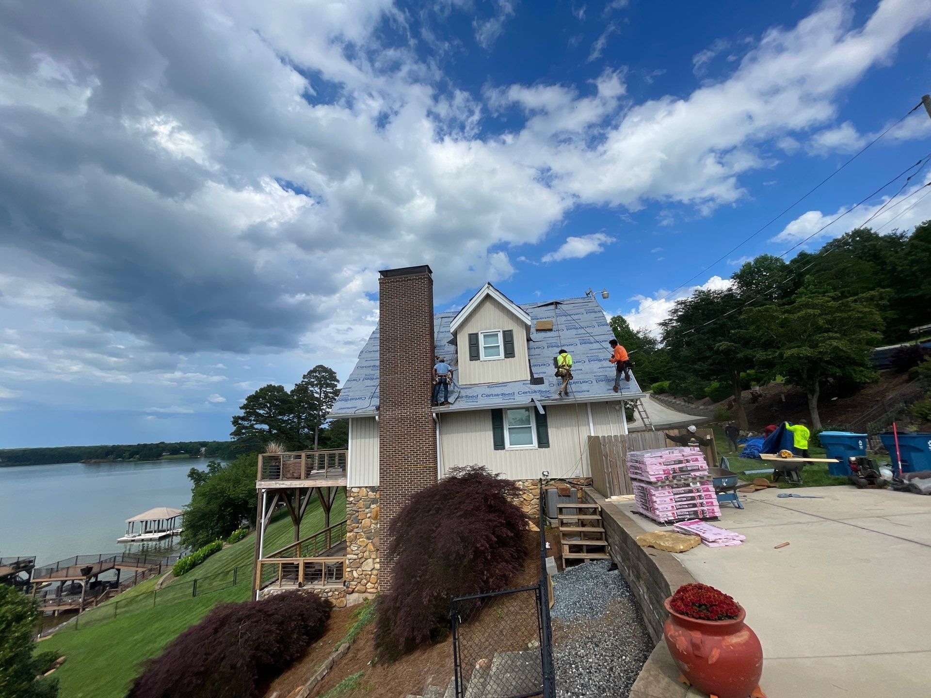 A group of people are working on the roof of a house.