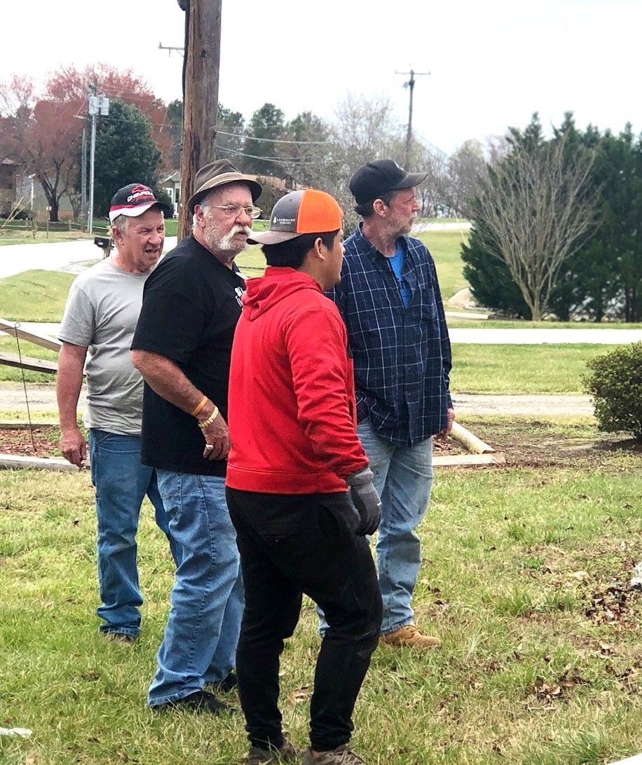 A group of men are standing in a grassy field.
