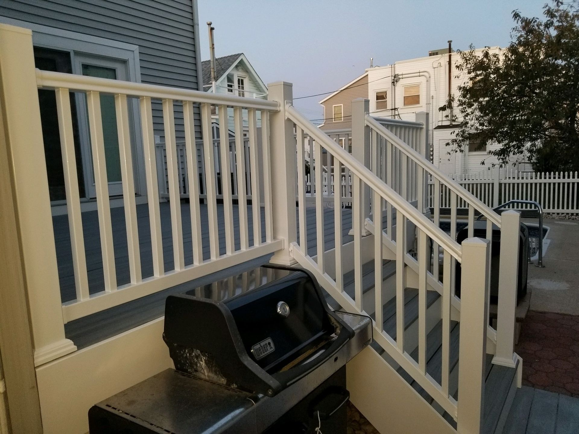 A grill is sitting on a deck next to stairs