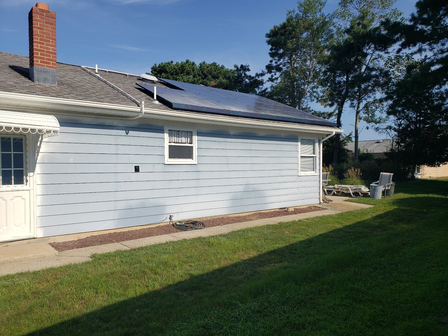 A blue house with solar panels on the side of it.