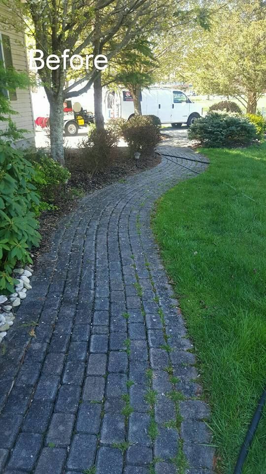 A before picture of a brick walkway in a yard.