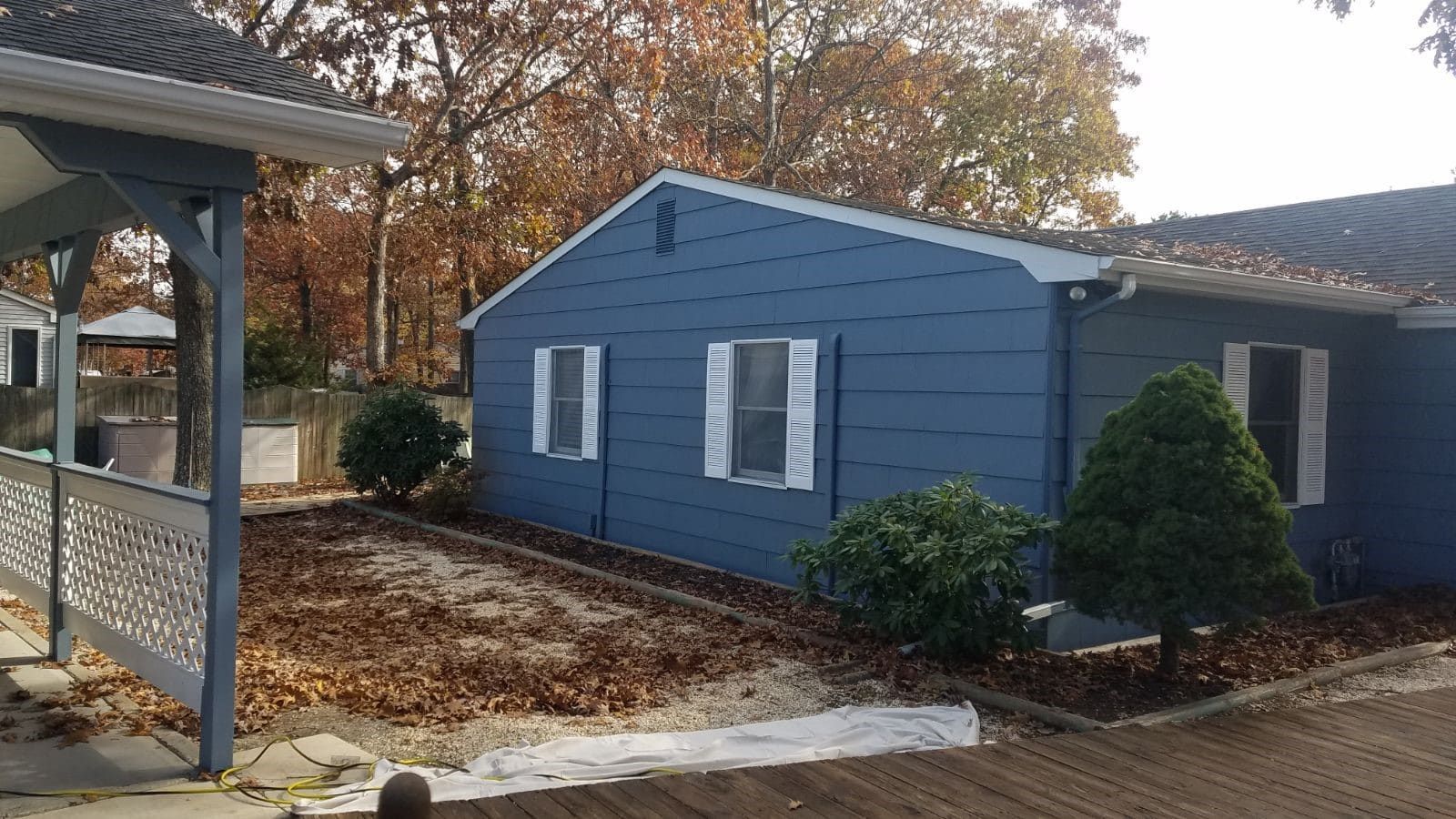 A blue house with white shutters on the windows