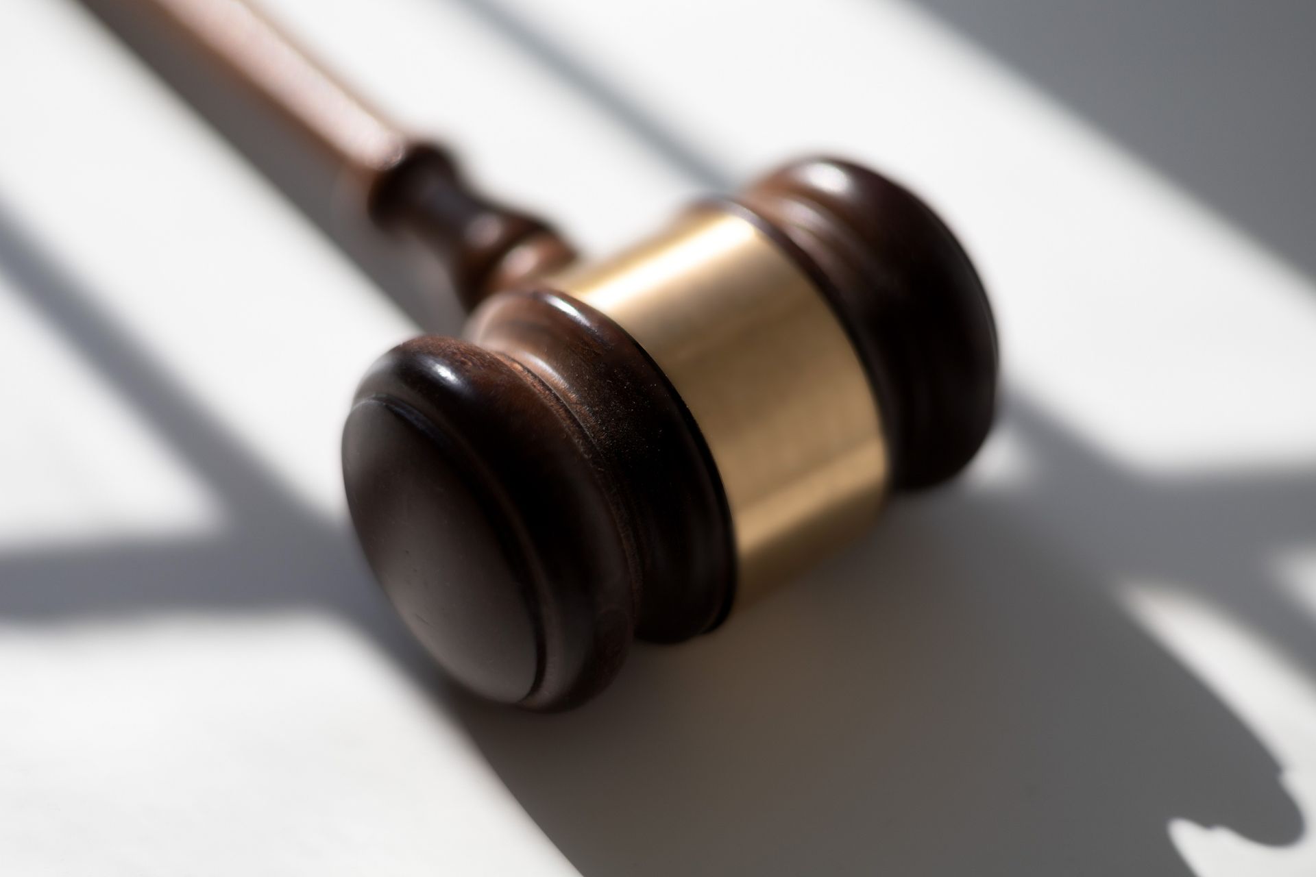 Close-up picture of a gold-trimmed wooden judicial gavel. 