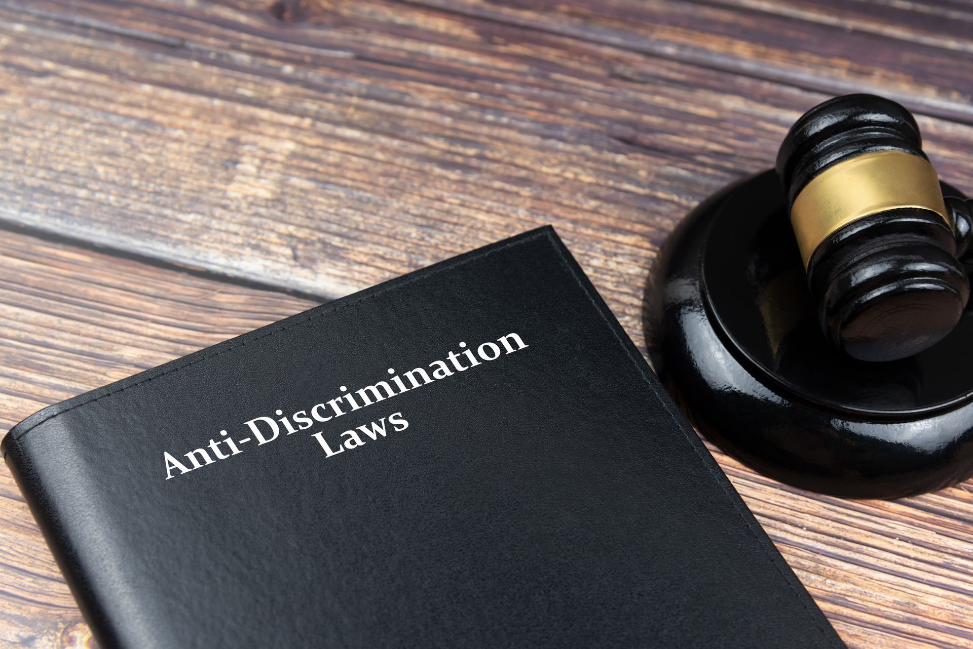 An anti-discrimination law book and a gavel on top of a desk. 
