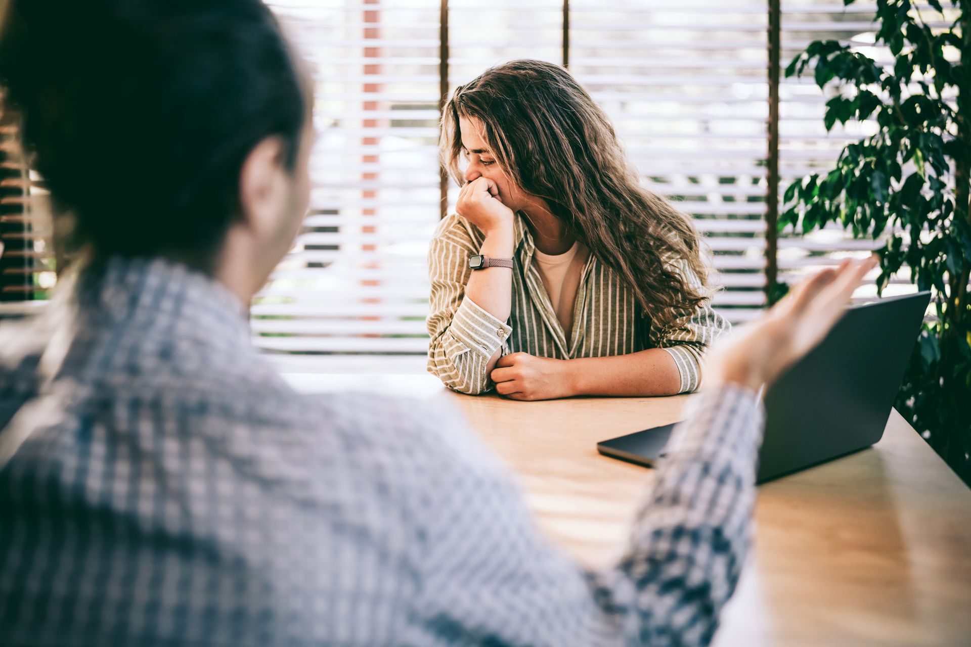 A woman consulting a discrimination legal attorney about workplace legal concerns in the office. A woman consulting a discrimination legal attorney about workplace legal concerns in the office.