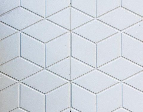 A close up of a white tile with a geometric pattern on it.