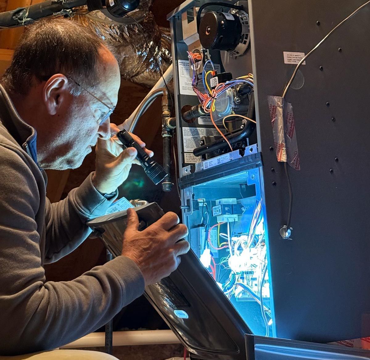 A man is working on a computer with a magnifying glass