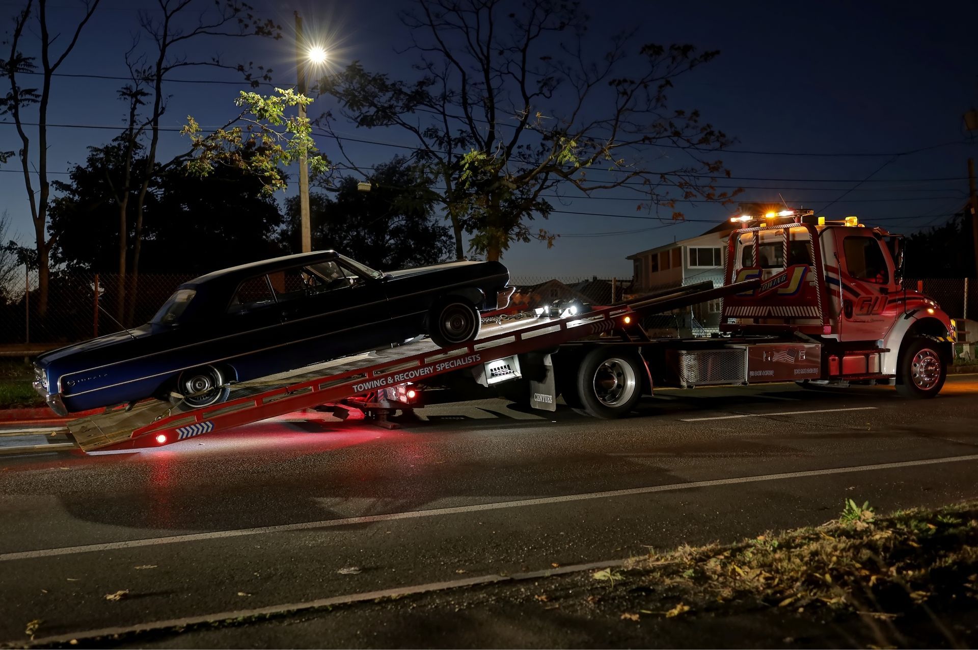 A damaged car loaded on a car hauler on a highway; sunny day.