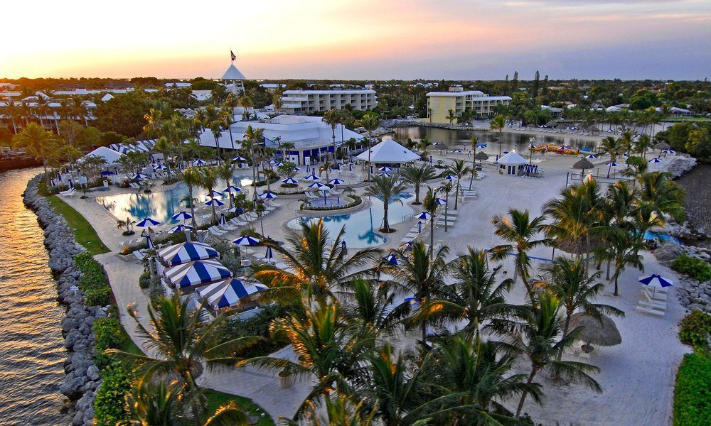 An aerial view of a marina with boats docked and a large lawn.
