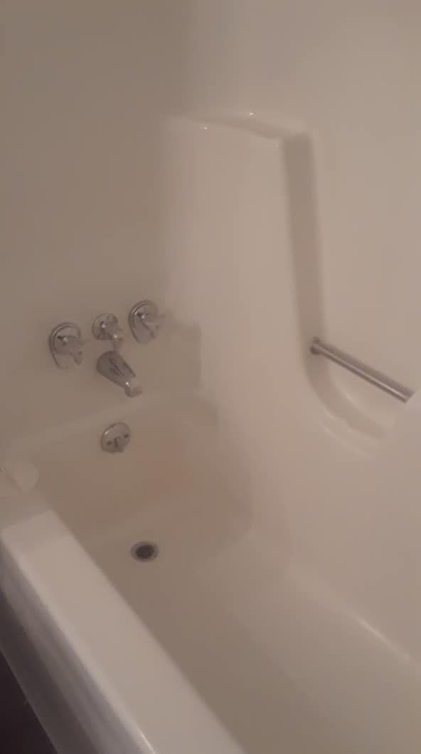 A white bathtub with a faucet in a bathroom.
