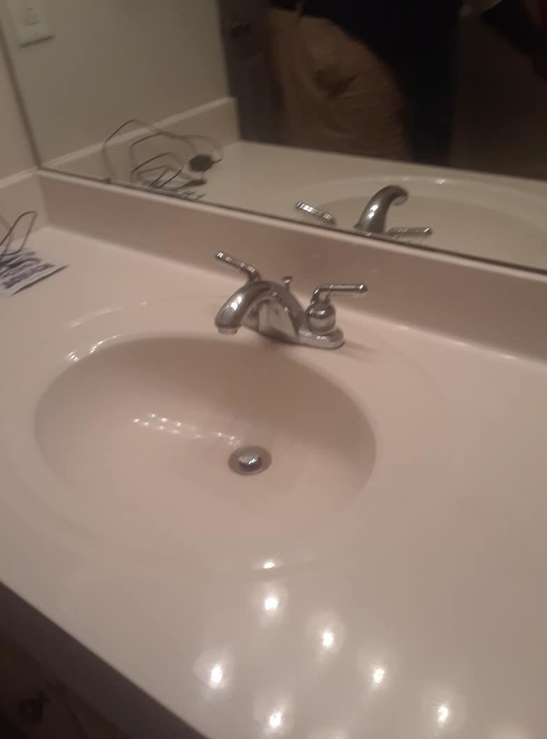 A bathroom sink with a faucet and a mirror.