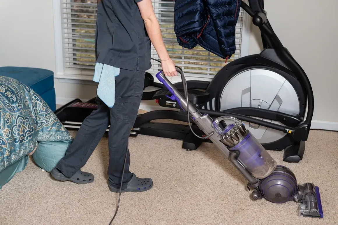 A person is using a vacuum cleaner in a living room.