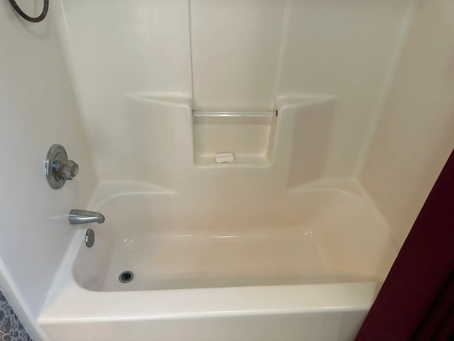 A white bathtub in a bathroom with a shower stall.