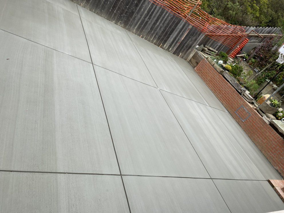 A concrete floor with a fence in the background