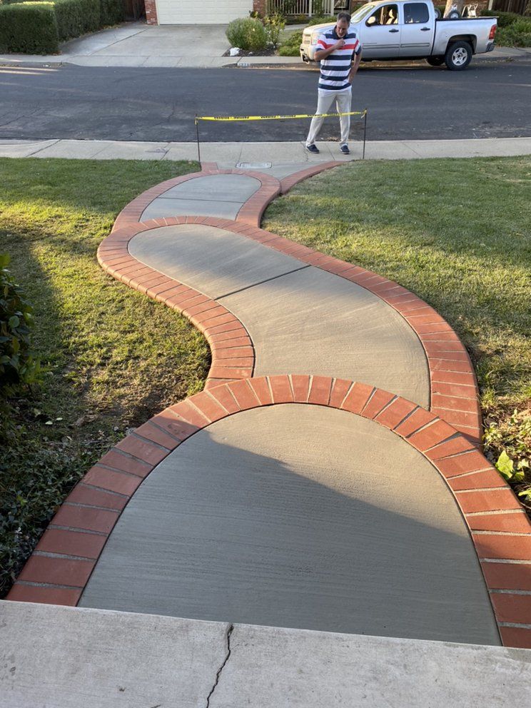 A man is standing on a curved concrete walkway.