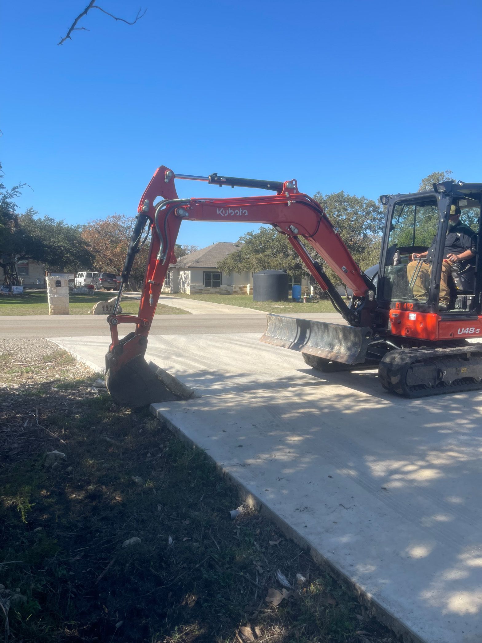 A red excavator is parked on the side of the road.