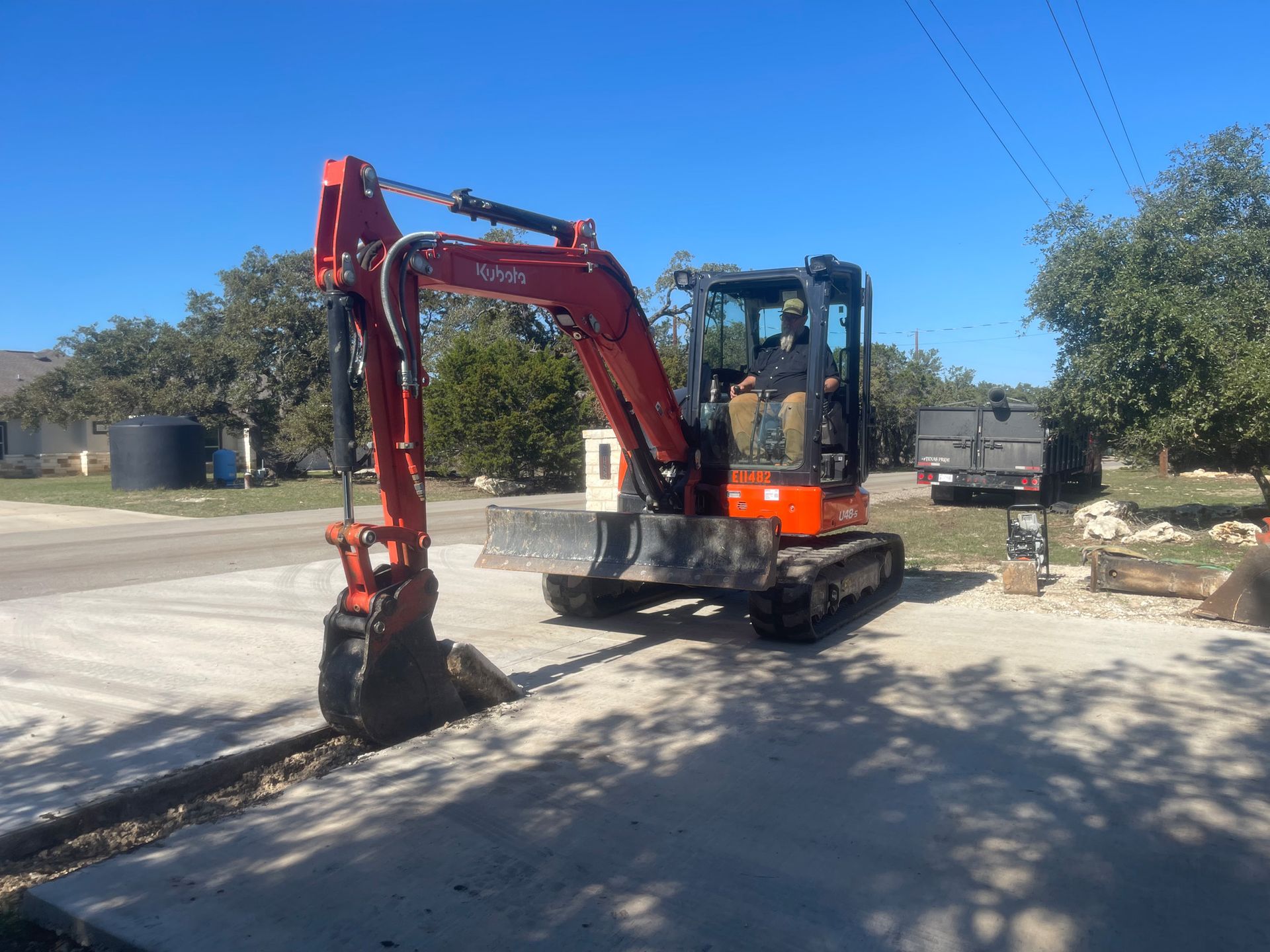 A red excavator is parked on the side of the road.