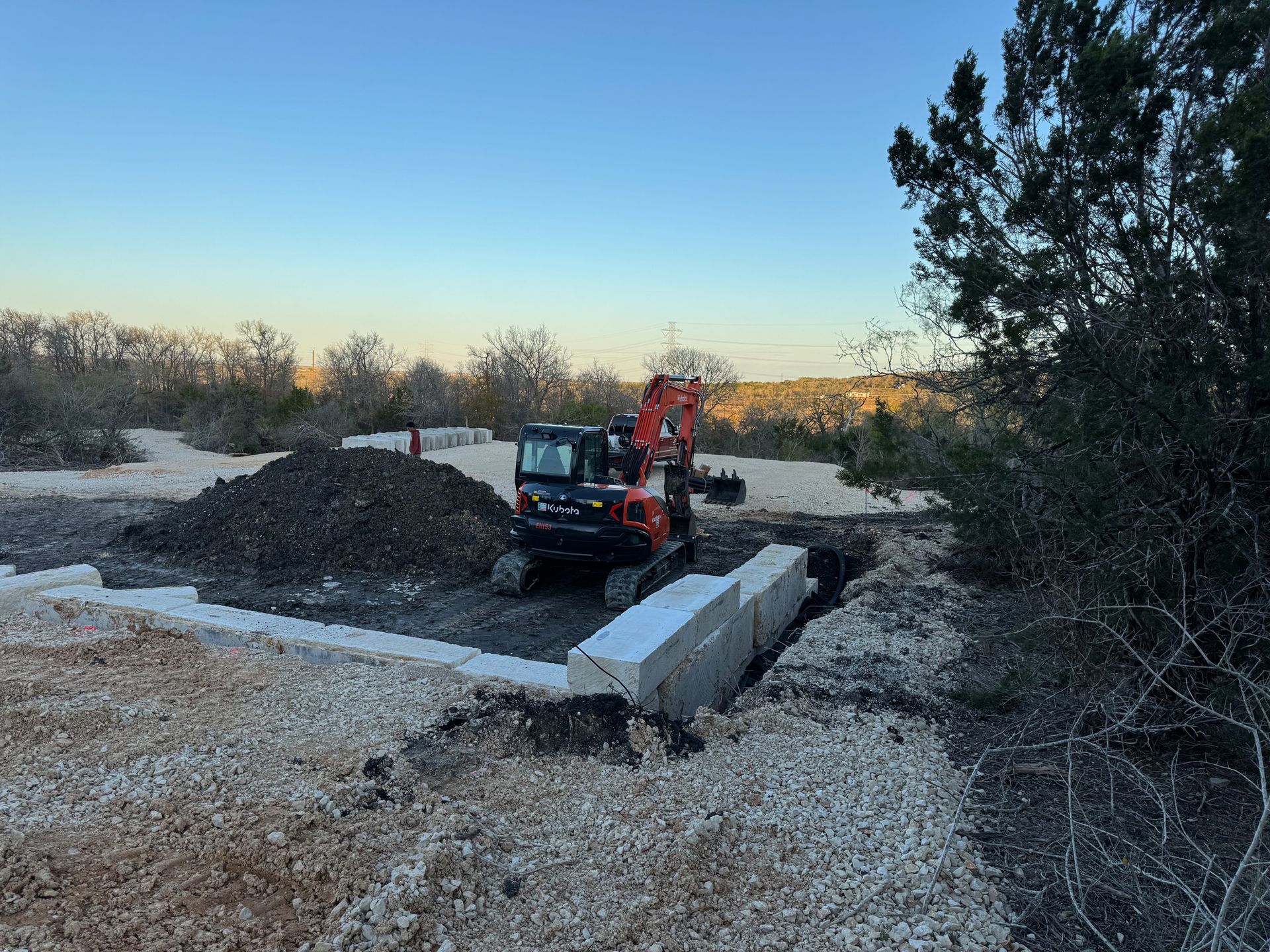 A bulldozer is sitting on top of a pile of gravel in a field.