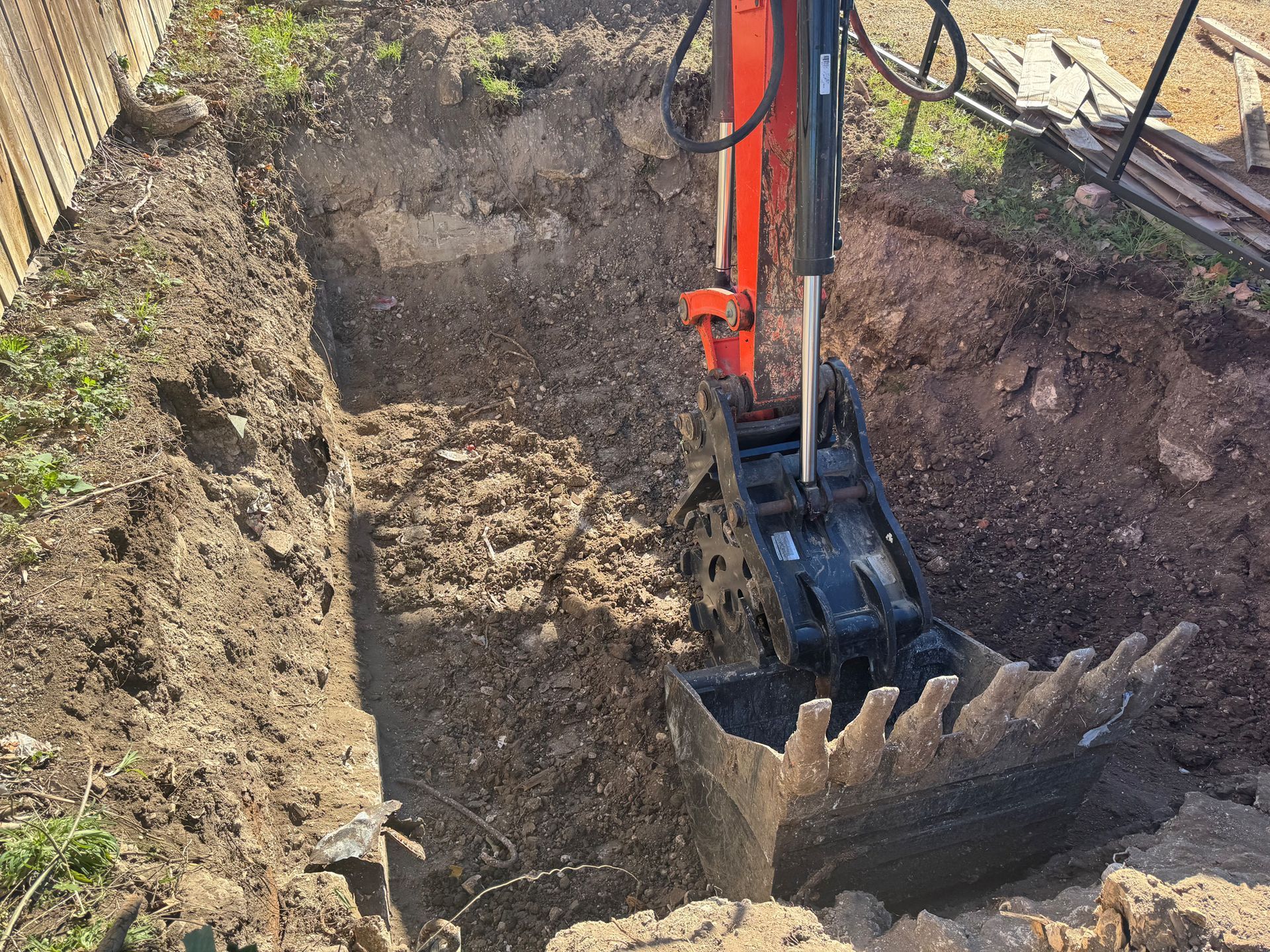 An excavator is digging a hole in the dirt.