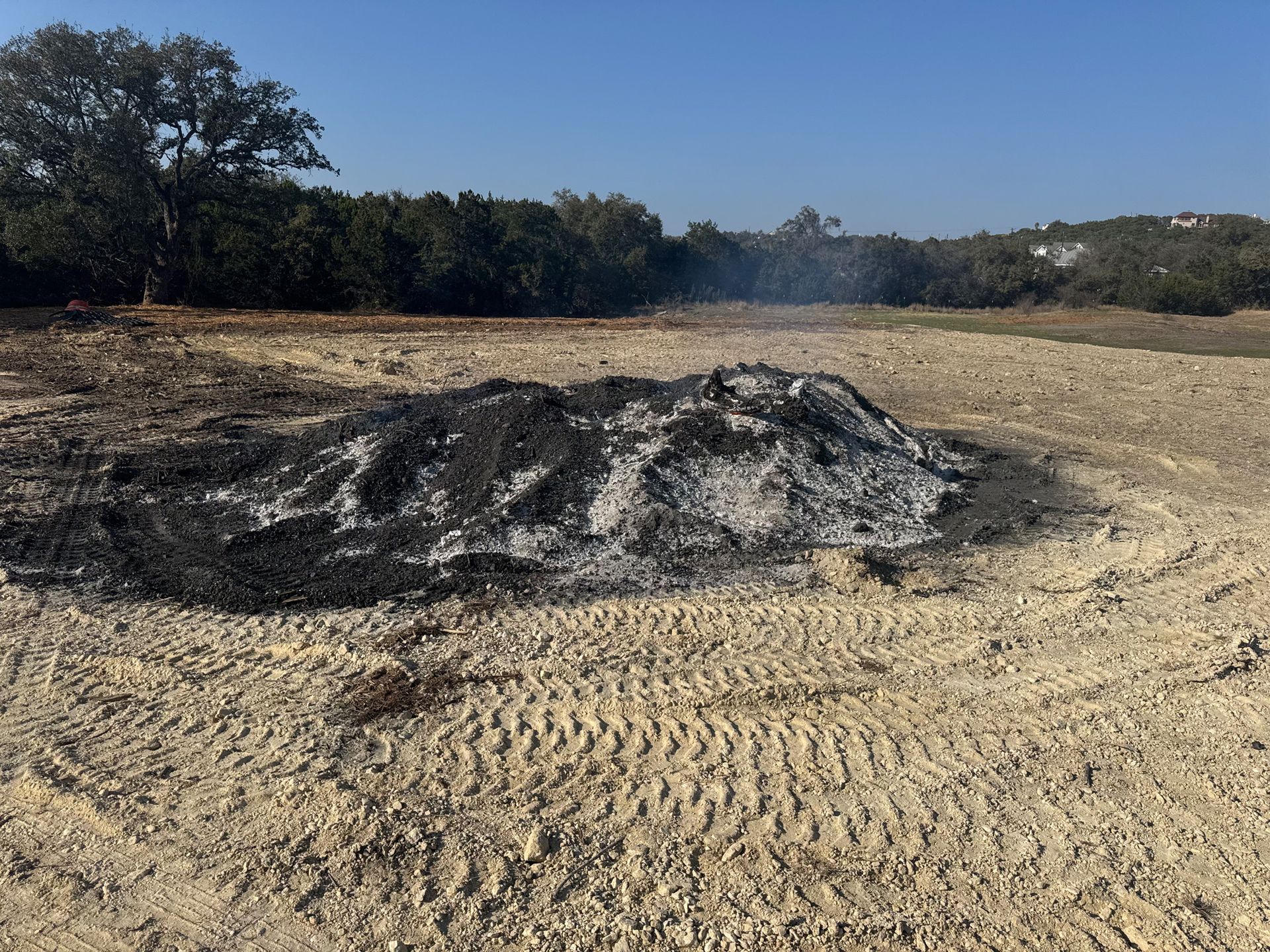 A large pile of dirt is sitting in the middle of a field.