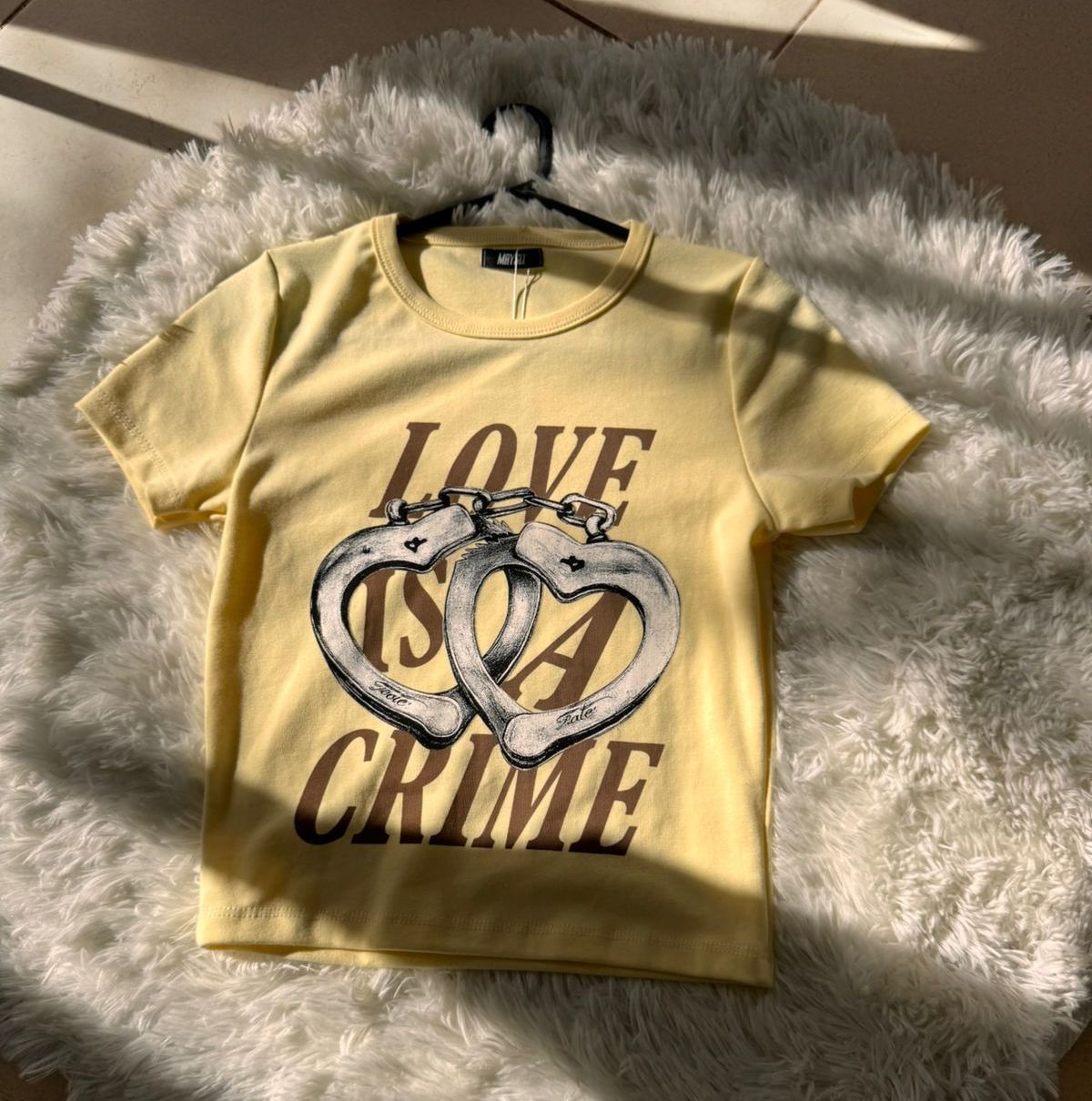 Camiseta amarilla con gráfico "El amor es un crimen