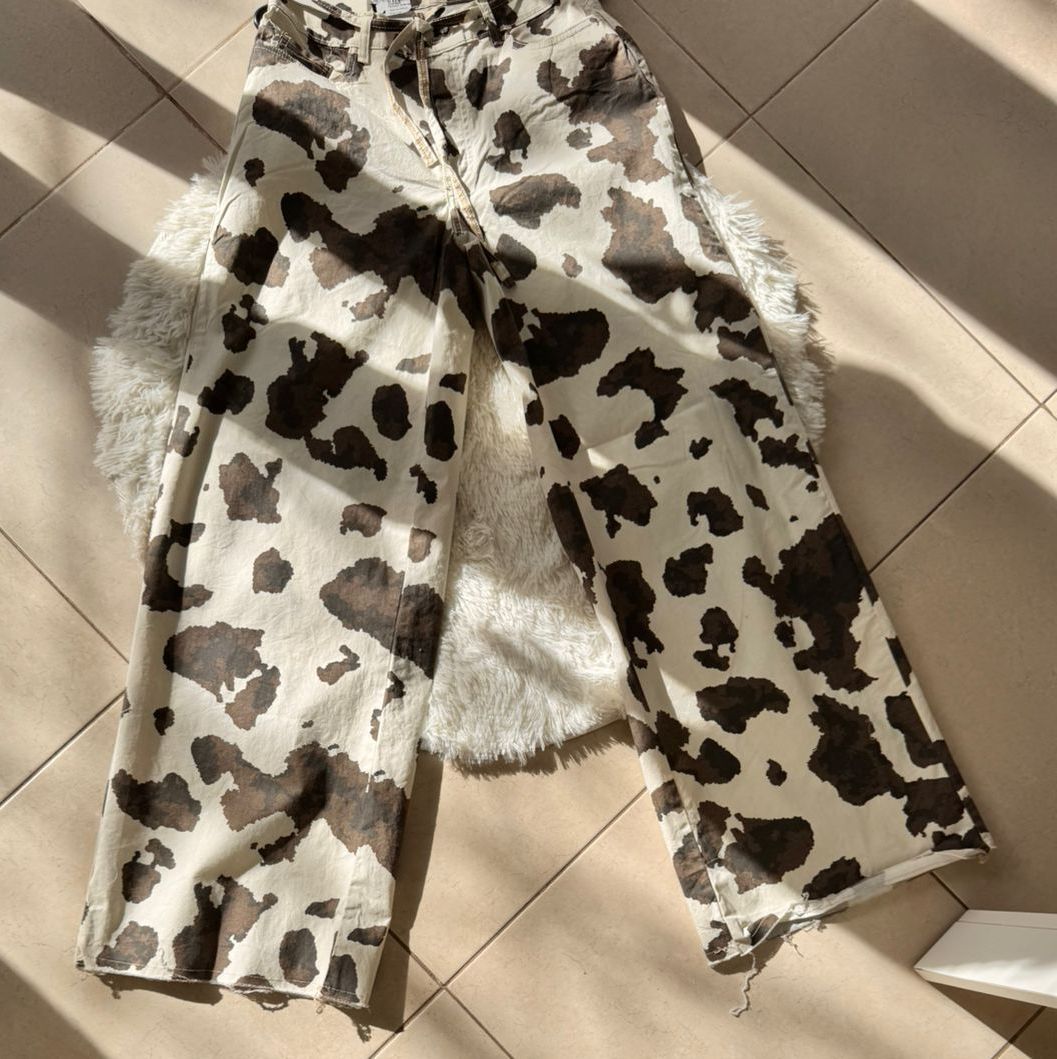 Vaqueros con estampado de vaca colocados sobre un suelo