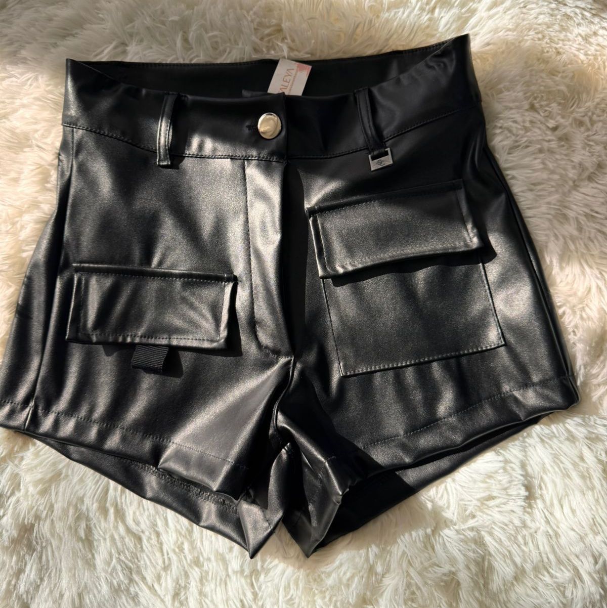 Pantalones cortos de cuero negro con bolsillos cargo.