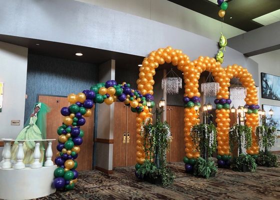 A room decorated with balloons and a woman in a green dress