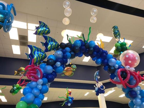 A bunch of balloons are hanging from the ceiling in a room