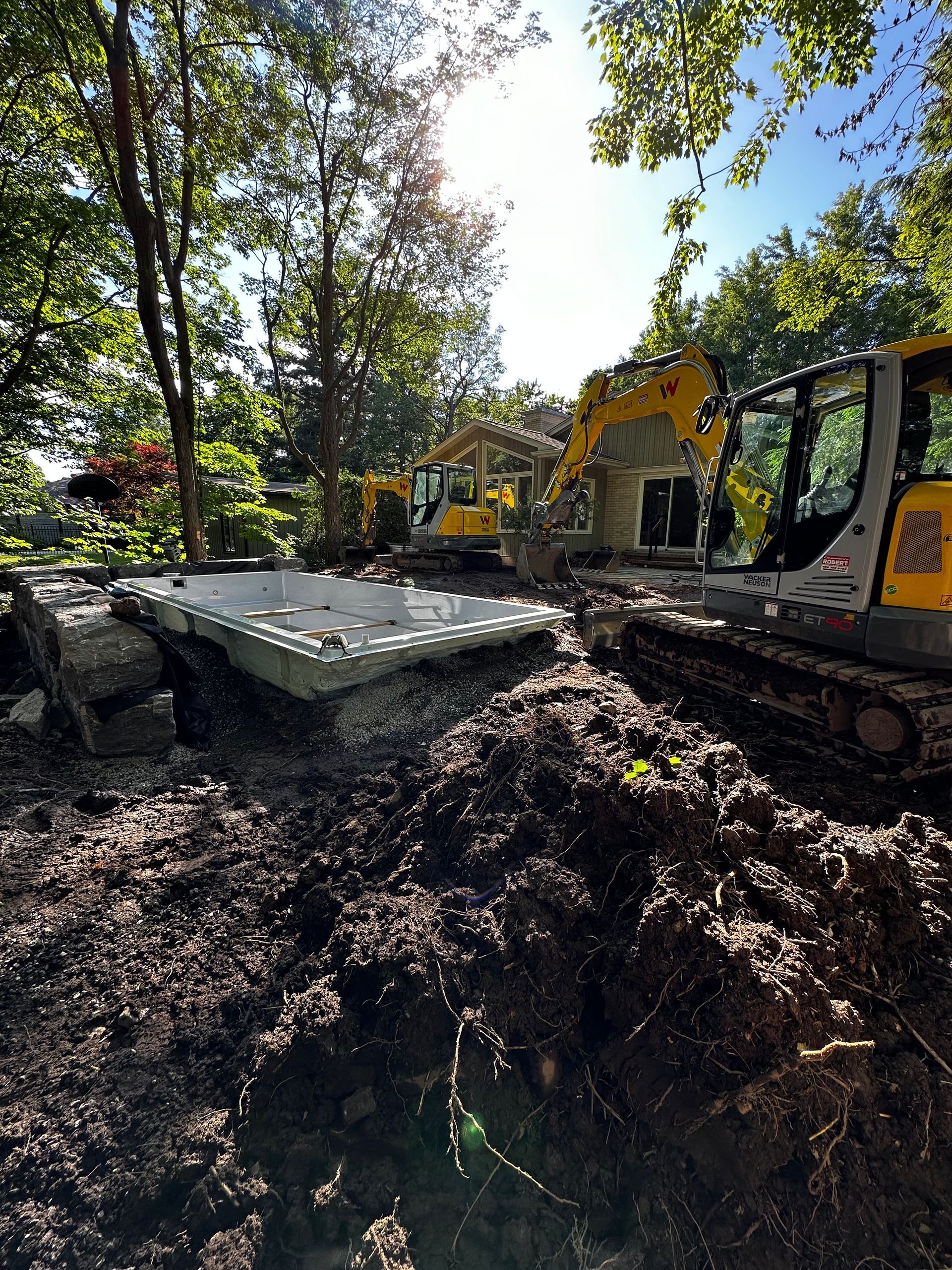 Un chantier de construction avec beaucoup de terre et d'arbres en arrière-plan