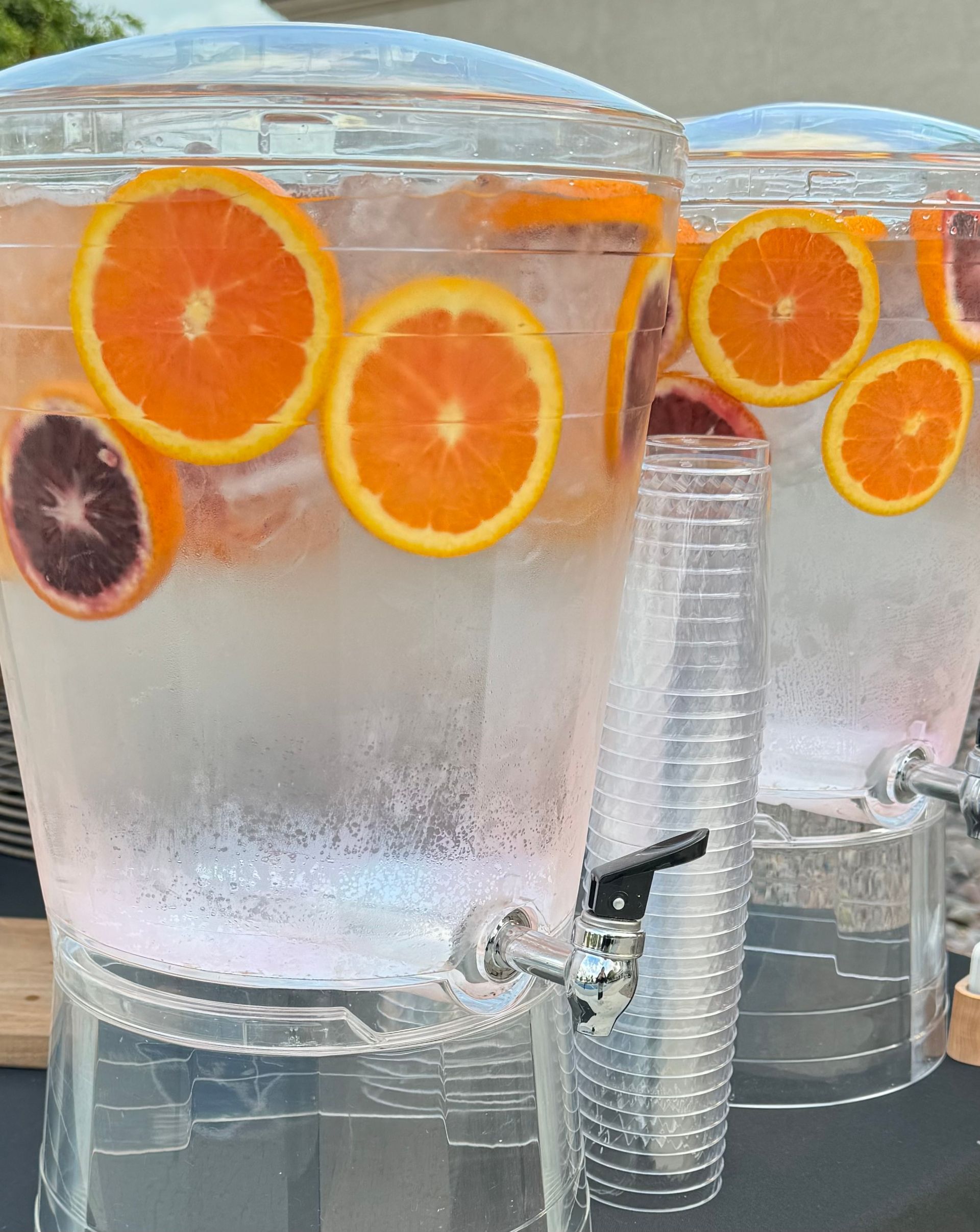 A glass of water with lemon slices and mint leaves splashing out of it.