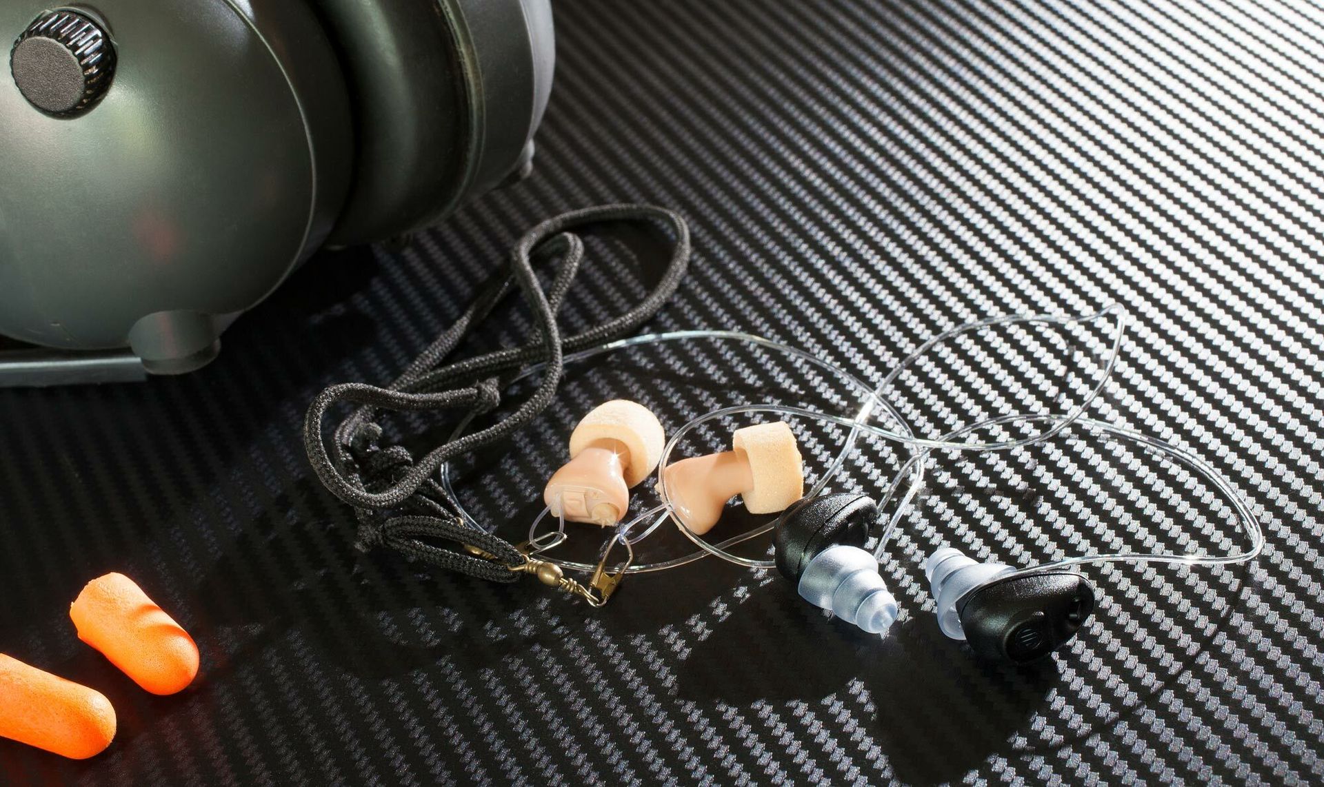 Assorted hearing protection including earmuffs and earplugs used for workplace noise reduction.
