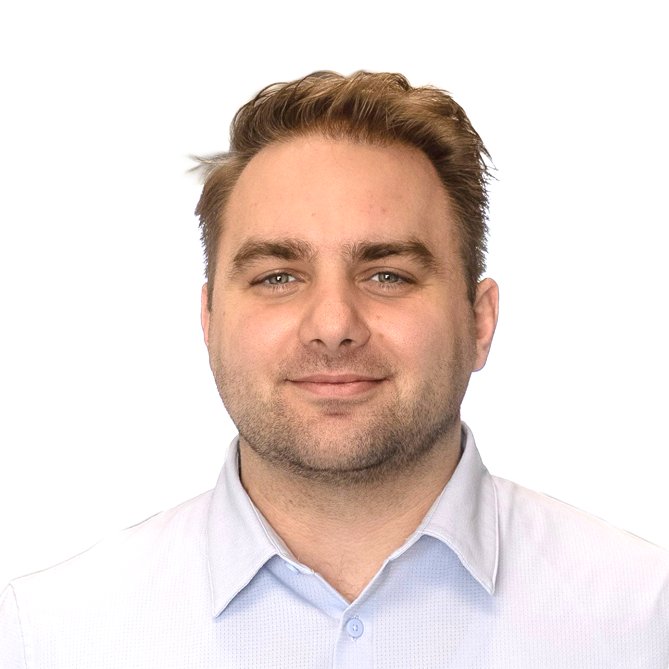 A man is smiling for the camera while standing in front of a wall.