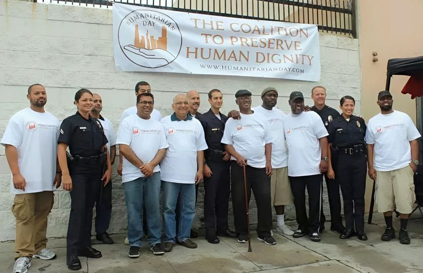 A group of people standing in front of a sign that says the coalition to preserve human dignity