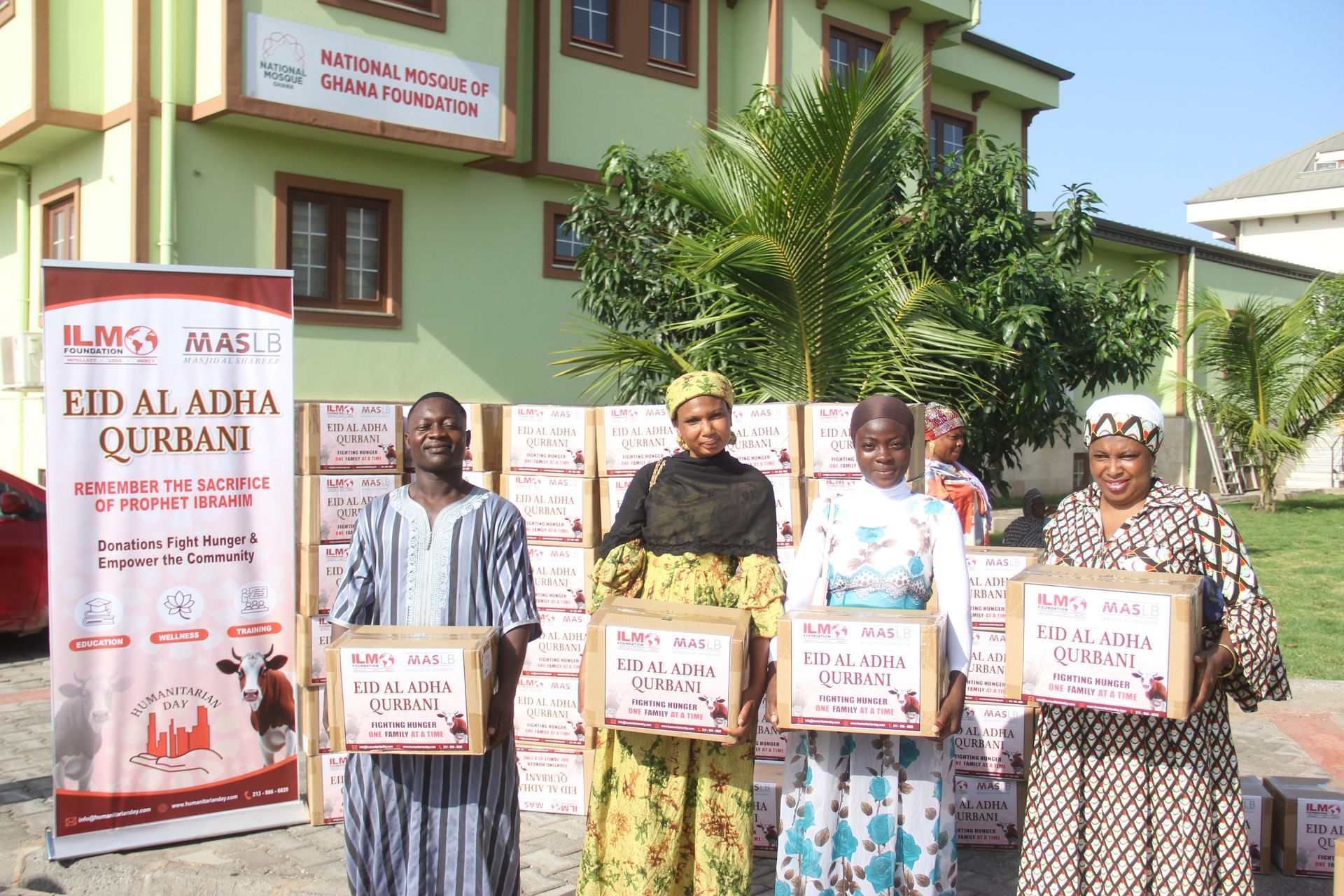 A group of people standing in front of a building holding boxes