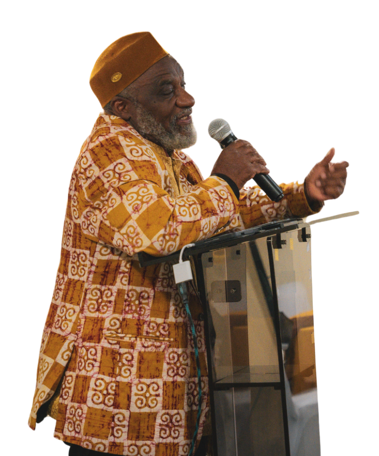 A man is standing at a podium holding a microphone.