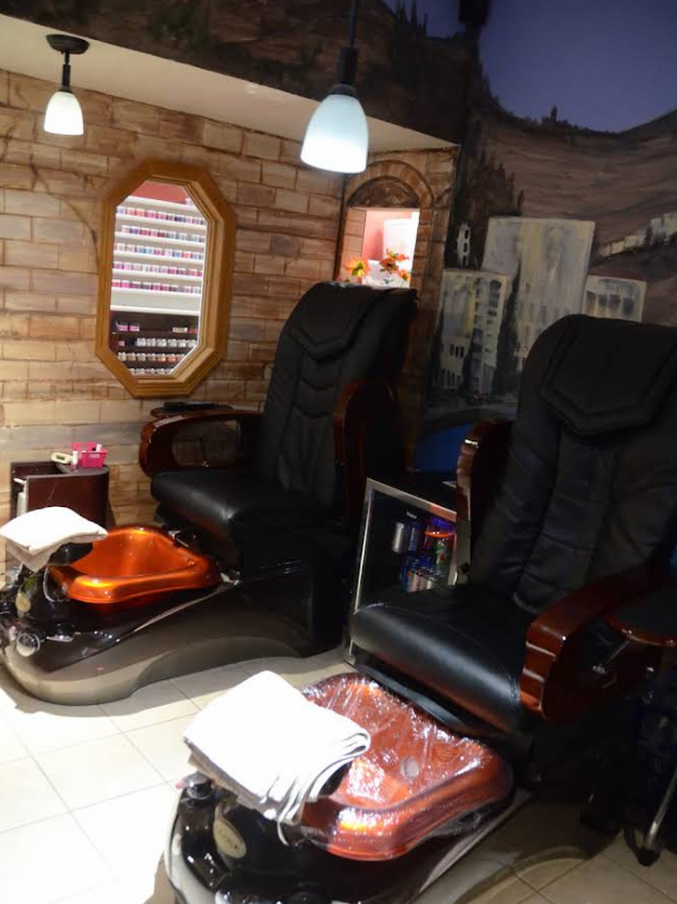 Two women 's feet with red nail polish are standing next to each other on a tiled floor.