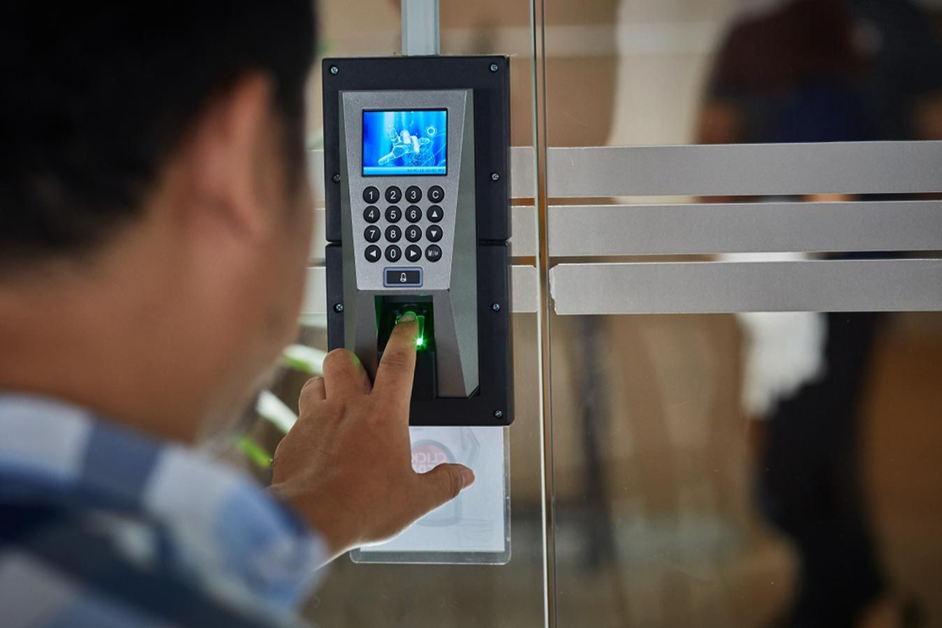User Accessing A Biometric Scanner To Unlock a Door — Cambush Security Solutions NT in Coconut Grove, NT