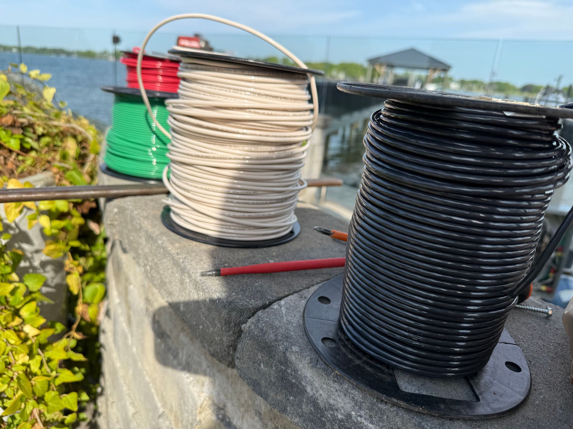 Electrician installing electrical outlet on a wall, using a screwdriver.