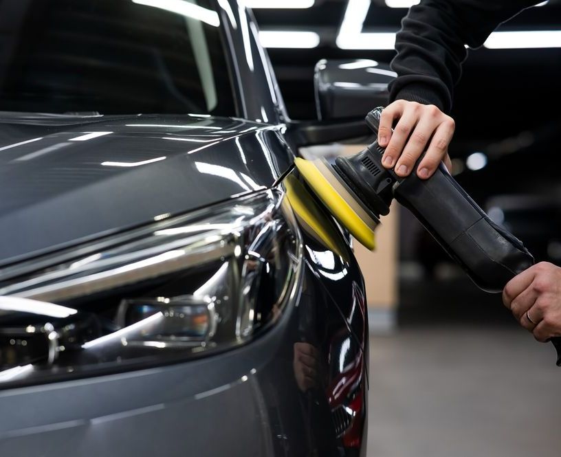 A person is polishing a car with a polisher