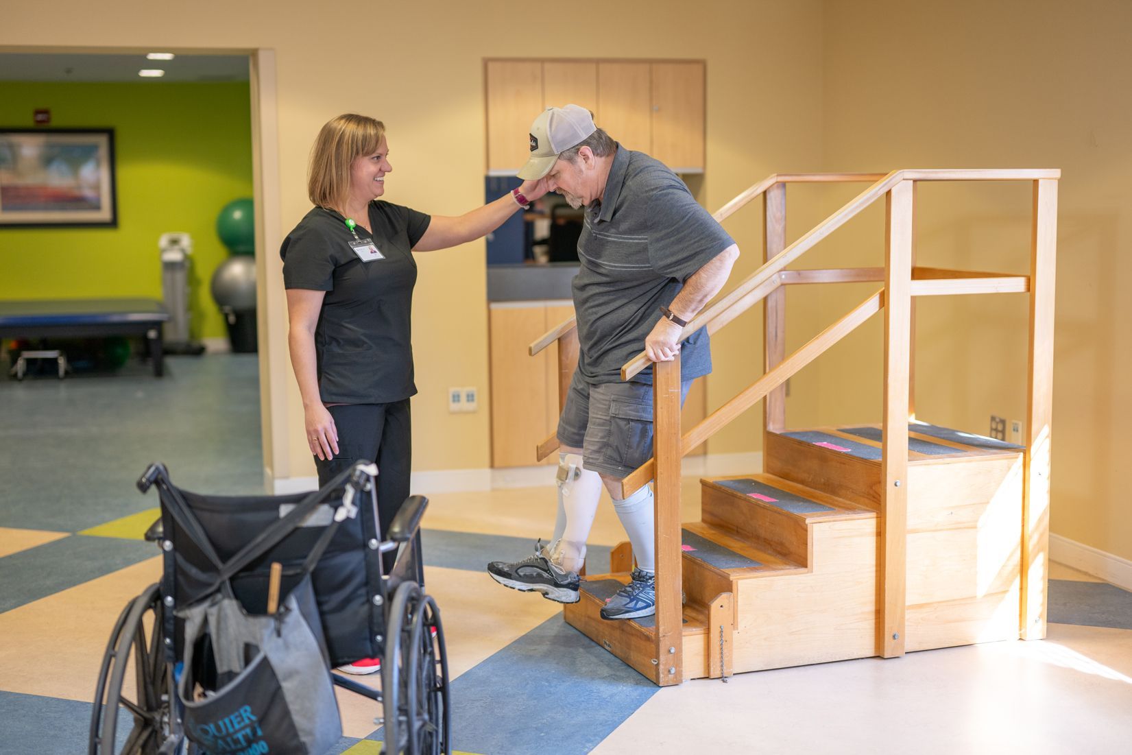 A woman is helping a man in a wheelchair climb stairs.