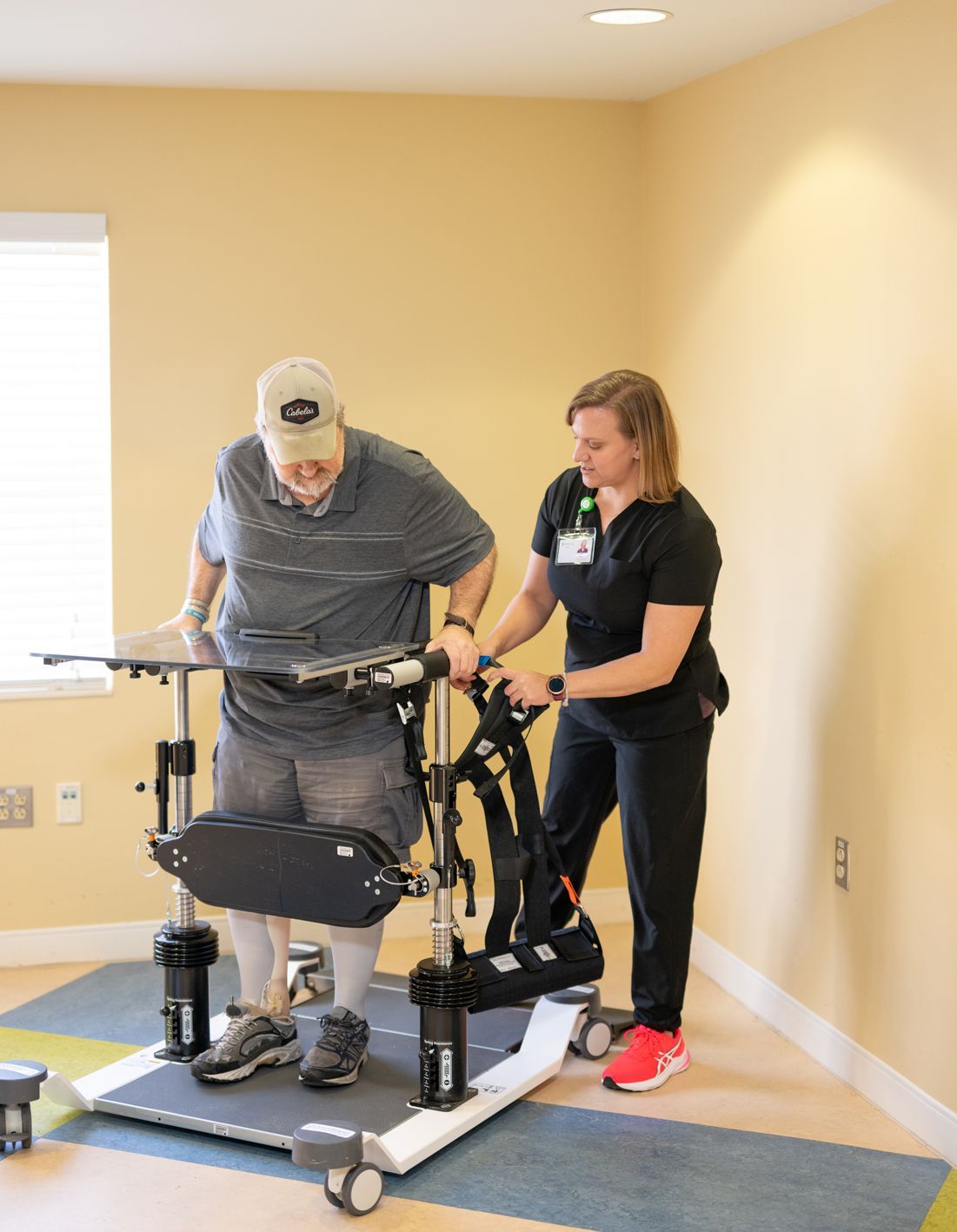 A woman is helping a man with a walker in a room.
