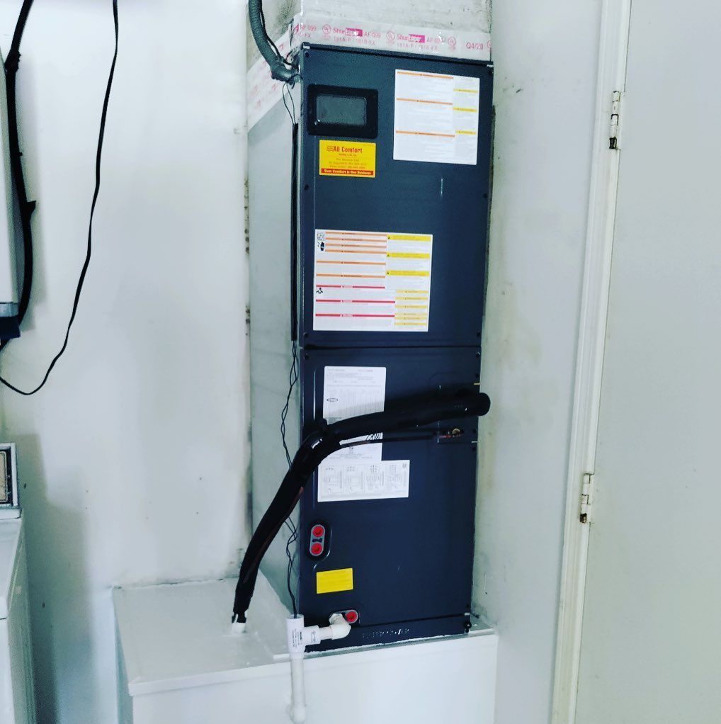 A refrigerator is hanging on a wall next to a door.