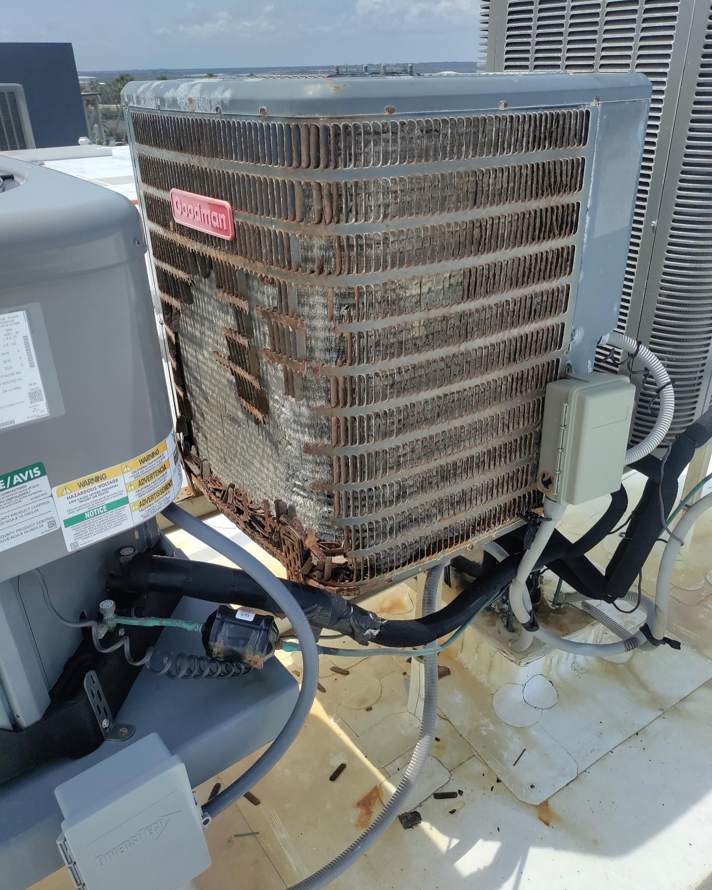 A rusty air conditioner is sitting on top of a roof.