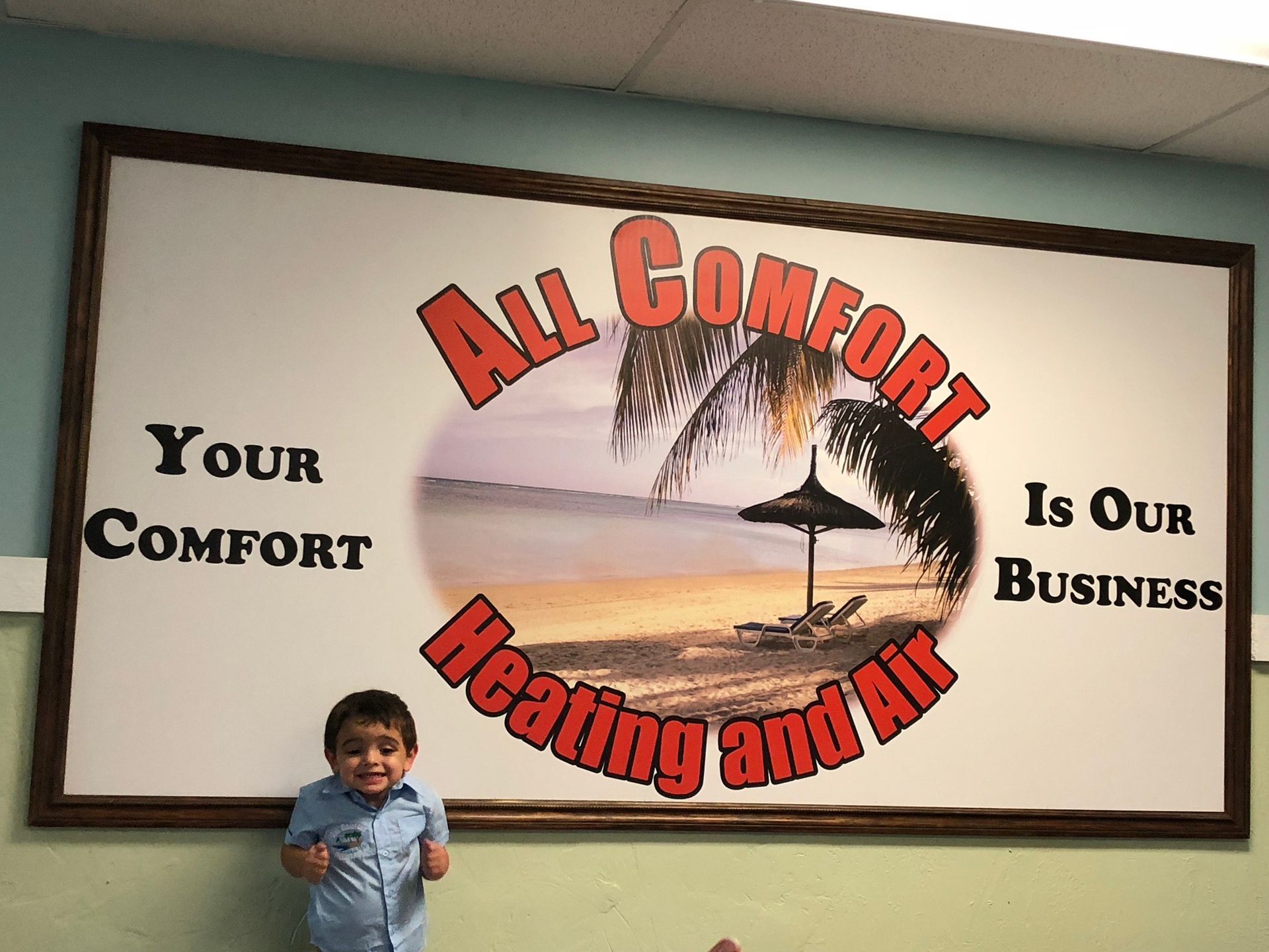 Young child stands near a sign for 