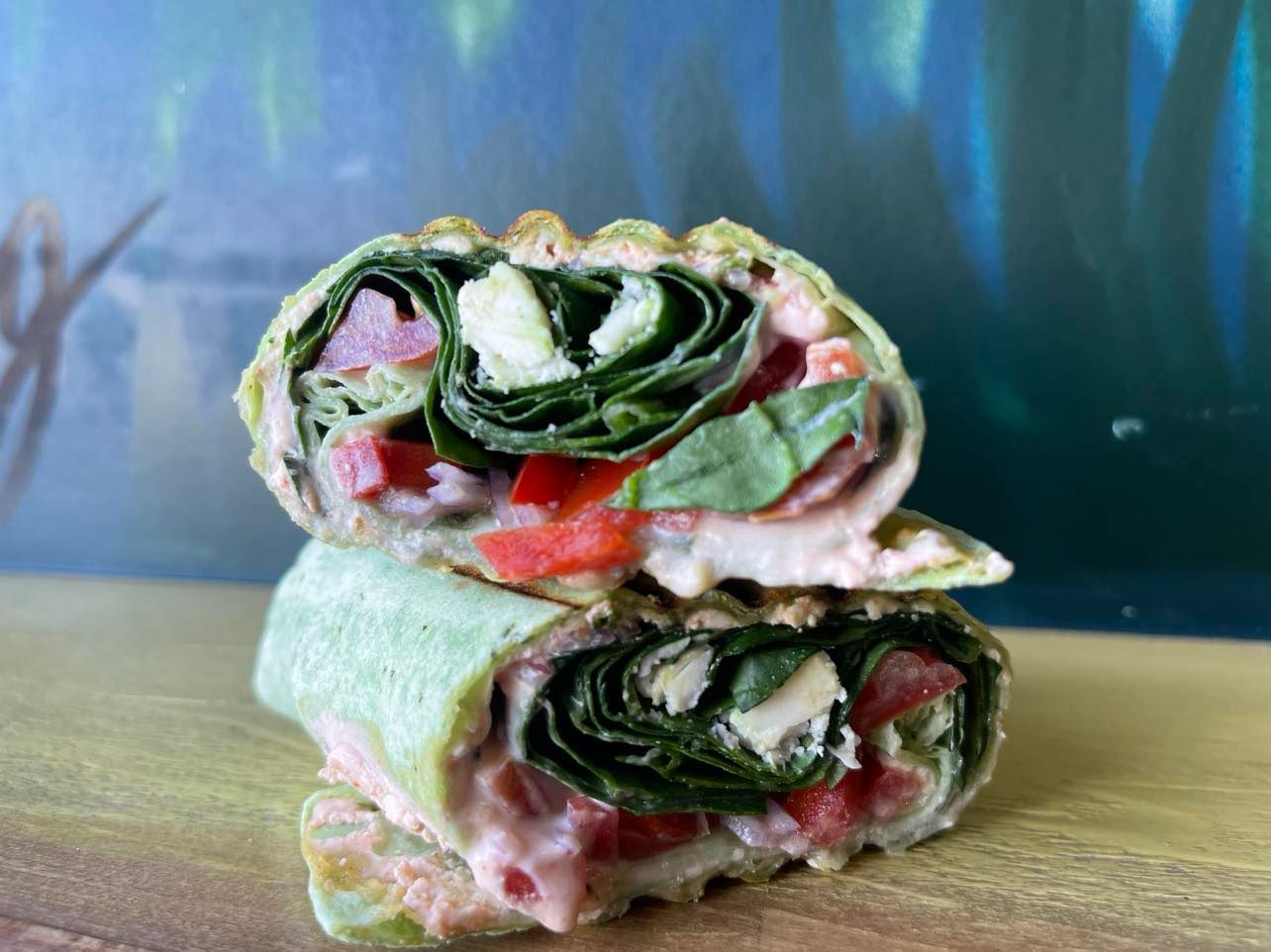 A close up of a Mediterranean toasted wrap stacked on top of each other on a wooden table.