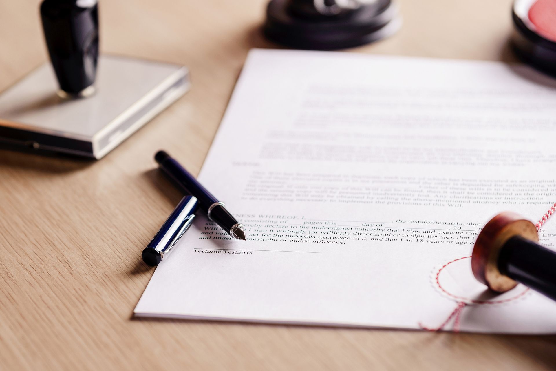 A person is signing a document with a stamp on it