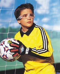 A young boy wearing goggles is holding a soccer ball.